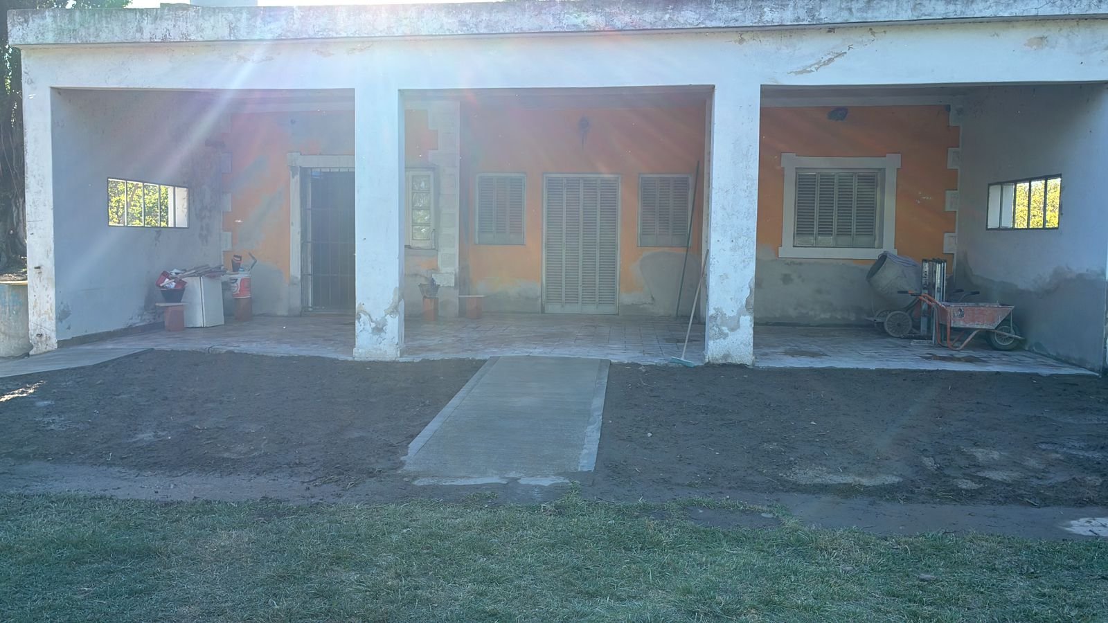 Exterior de construcción con galerías y jardín — proyecto Chacra JE, por Atelier de Diseño Interior - Luján Macia, en Río Colorado